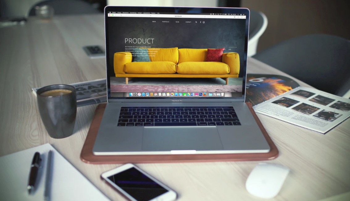 An image of a laptop with a website featuring a couch open on its screen.
