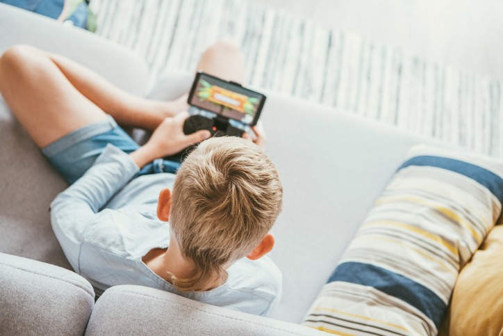Child plays using game streaming service on a sofa