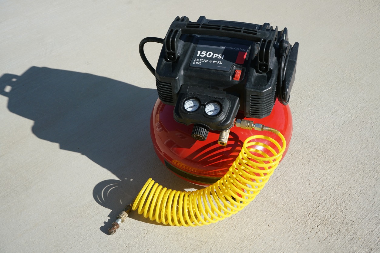 Portable electric air compressor with coiled hose